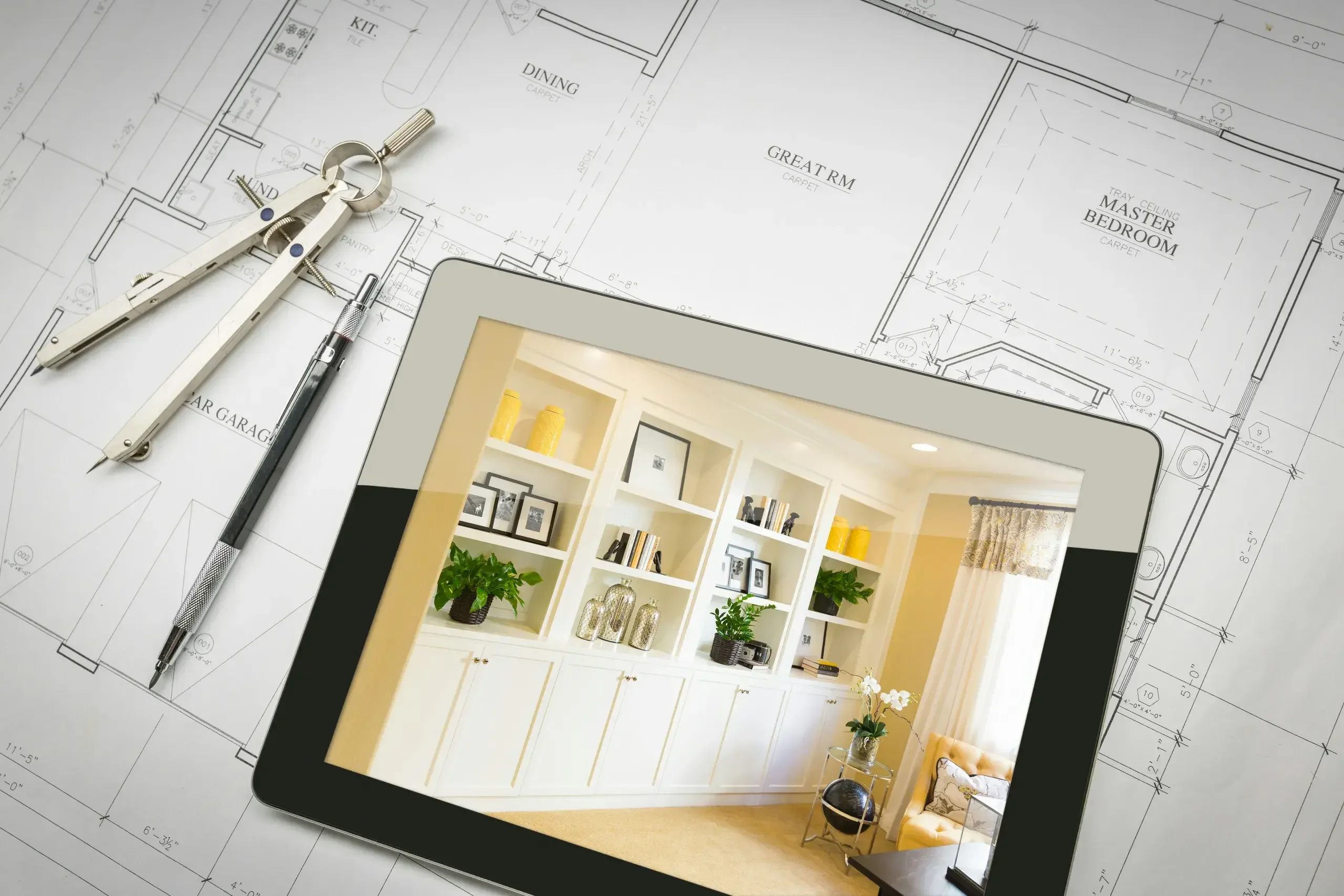 Planos arquitectónicos sobre el escritorio con herramientas, tablet con la visualización del interior
